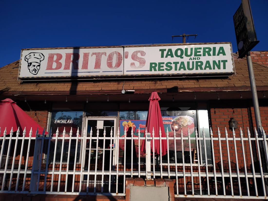 Brito's Taqueria and Restaurant sign with chef logo above the patio fence